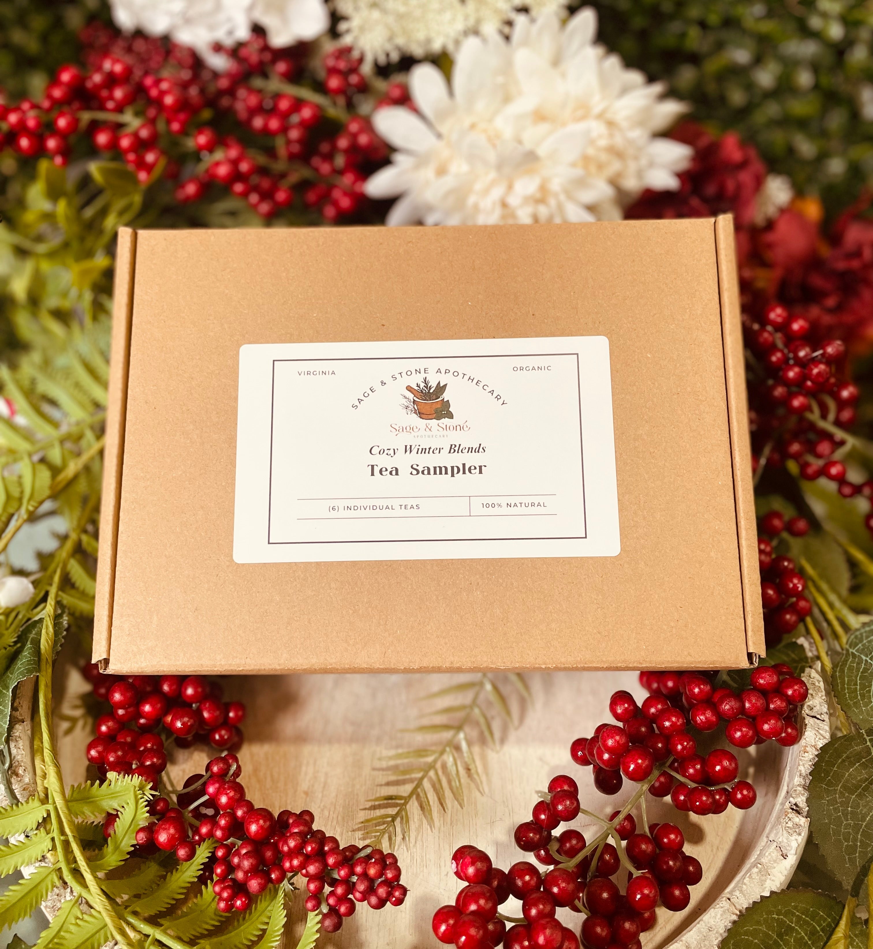 Assorted cozy winter tea sampler from Sage & Stone Apothecary, featuring various herbal and fruit tea blends in festive packaging.