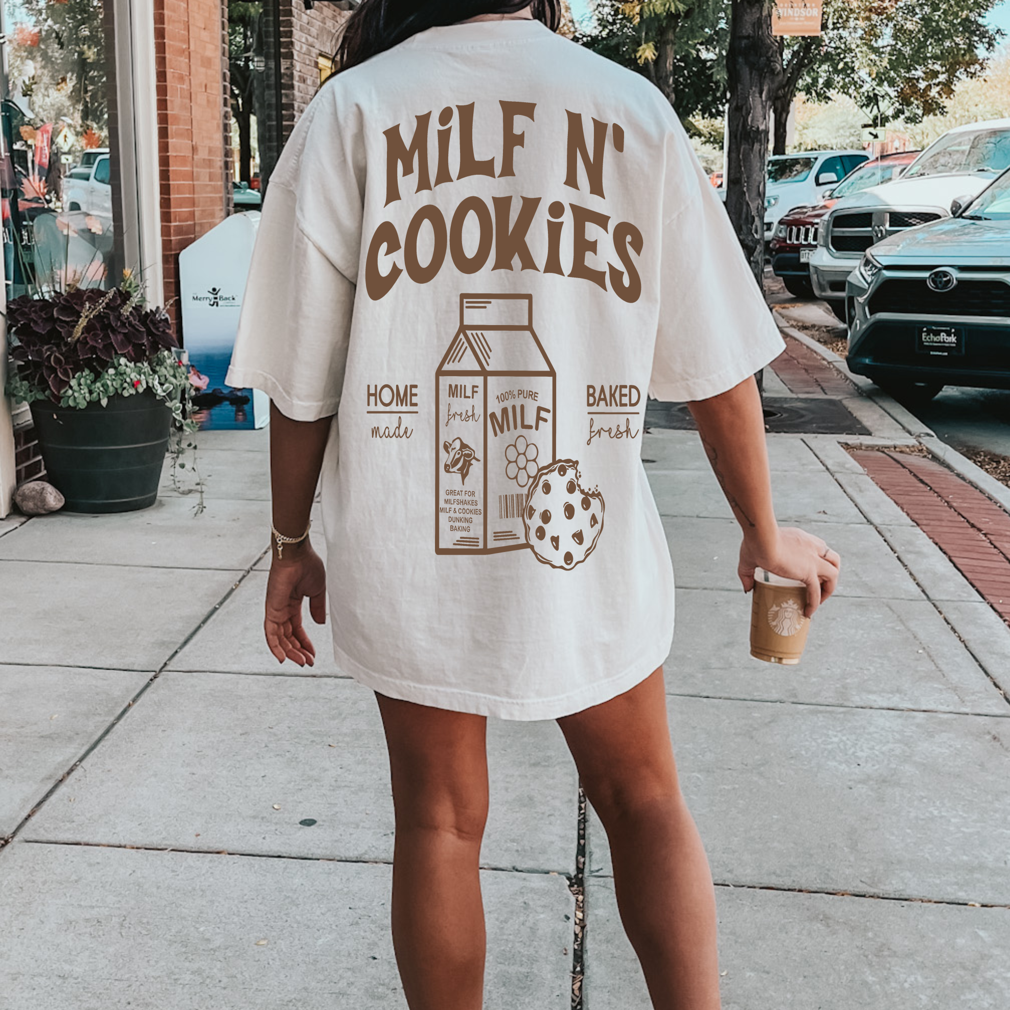 Graphic T-shirt featuring "Milf and Cookies" design by Shop Karma Tees, with bold text and playful style on a casual cotton tee.