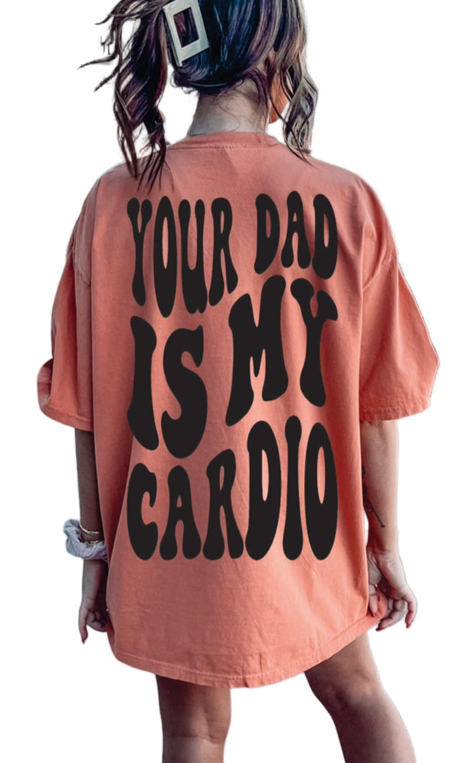 Gray graphic tee from Shop Karma Tees with "Your Dad Is My Cardio" slogan and casual fit, displayed on a hanger.
