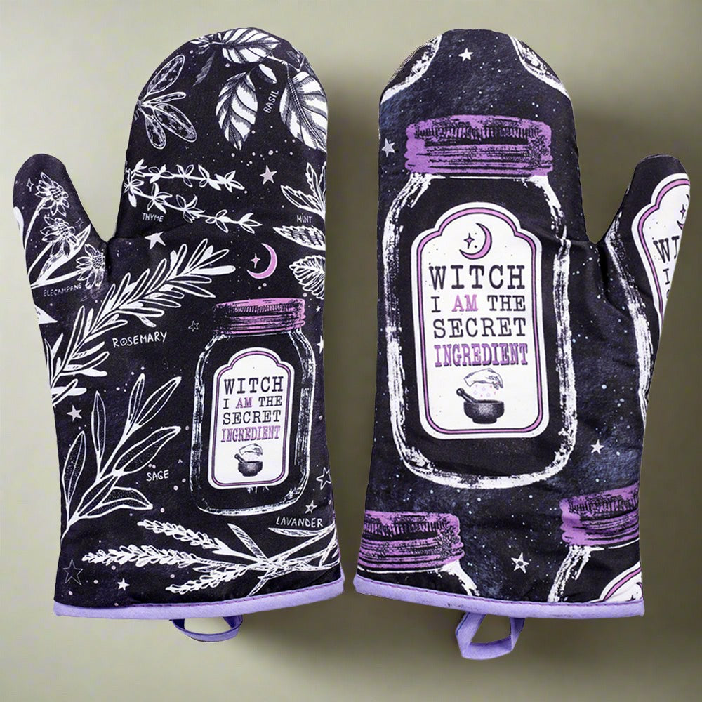 Pair of purple and black kitchen witch oven mitts with herb designs from Spirit Nest, perfect for baking and cooking.