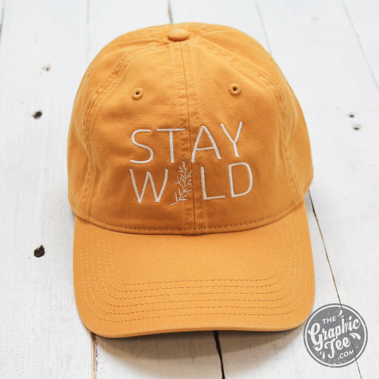 Relaxed mustard twill dad hat with "Stay Wild" embroidered in black, featuring a curved brim and adjustable strap.