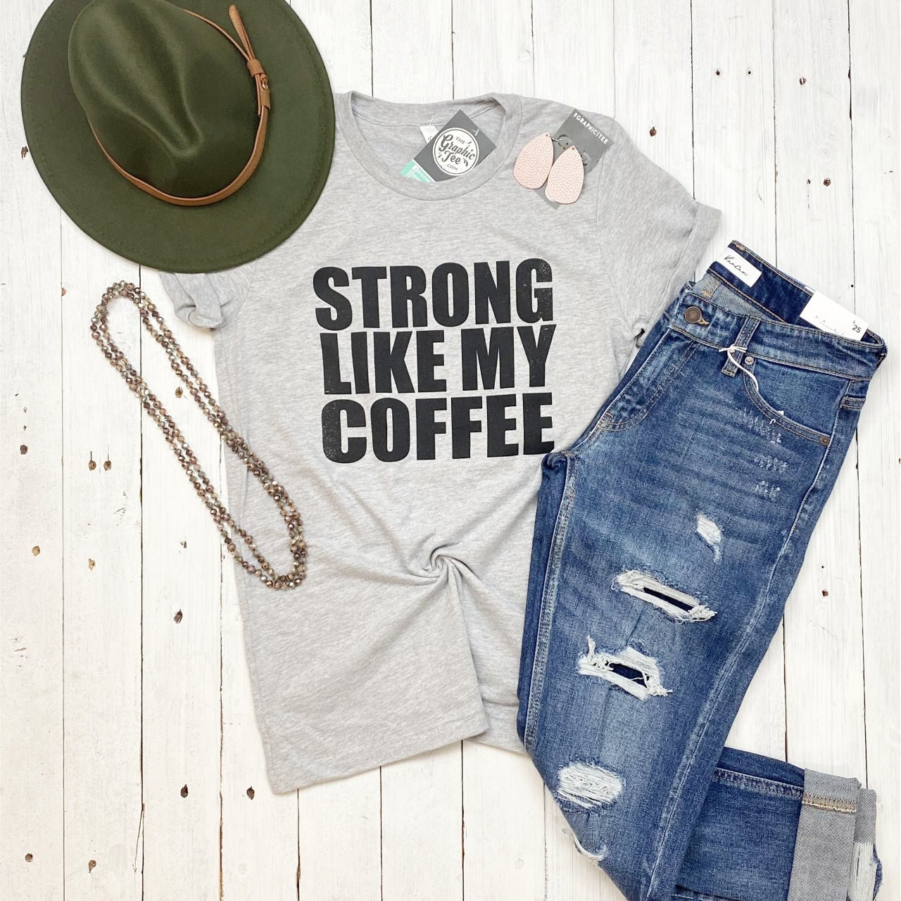 Unisex graphic tee from The Graphic Tee featuring "Strong Like My Coffee" slogan on a stylish short-sleeve design.