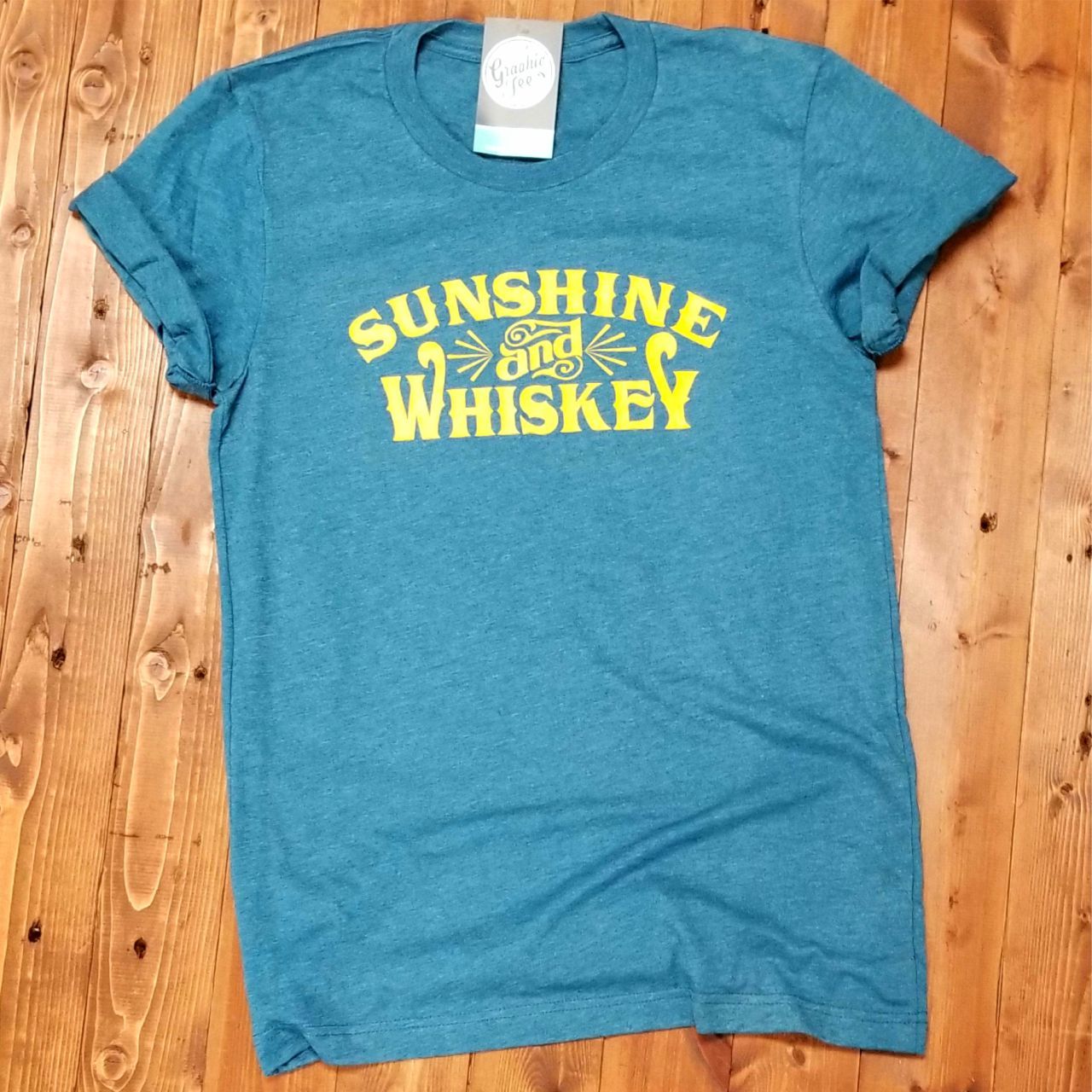 Sunshine and Whiskey unisex SS graphic tee from The Graphic Tee, featuring a vibrant sunny and whiskey-themed design.
