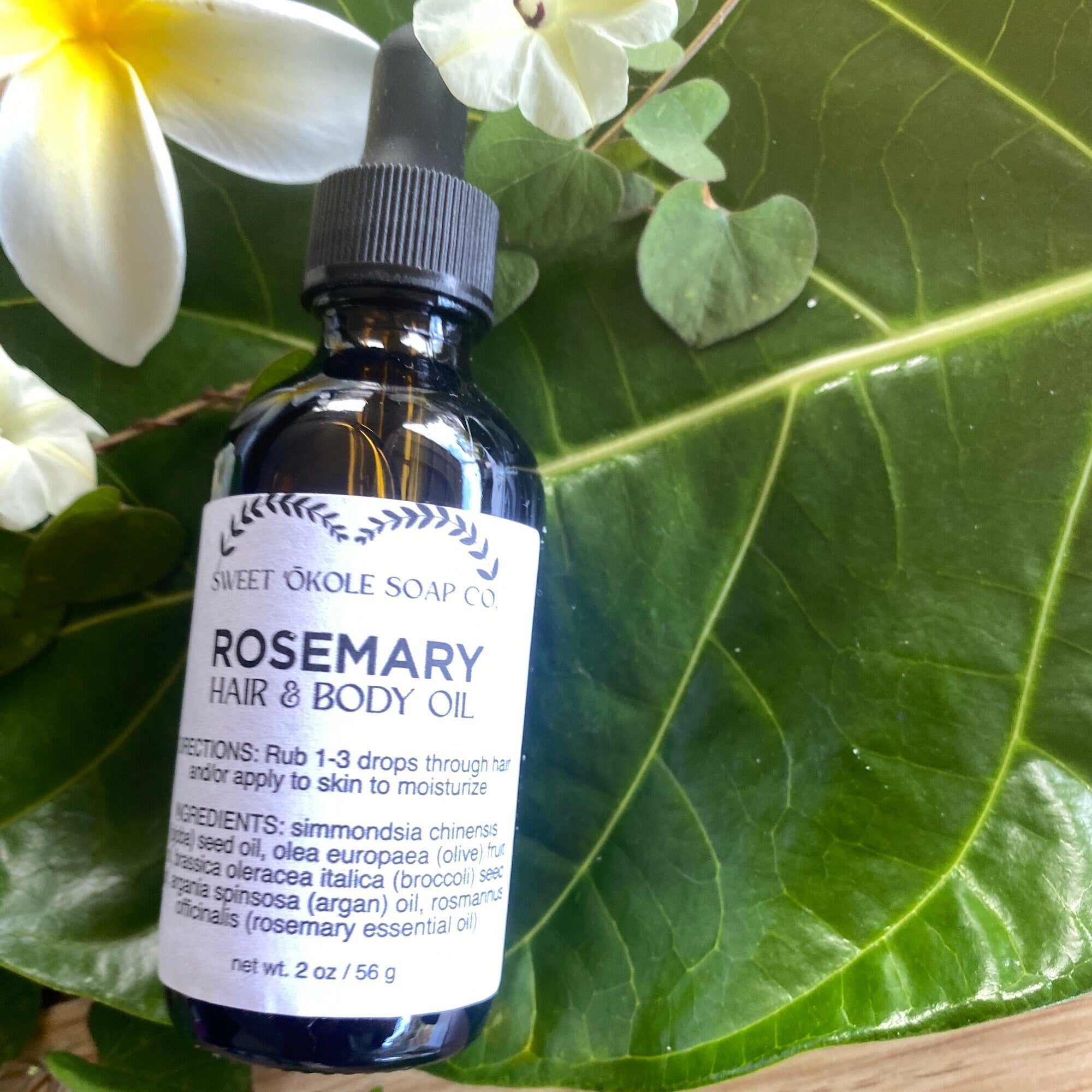 Bottle of Sweet ʻŌkole Soap Rosemary Hair & Scalp Oil with a clear label and dropper cap, set against a neutral background.