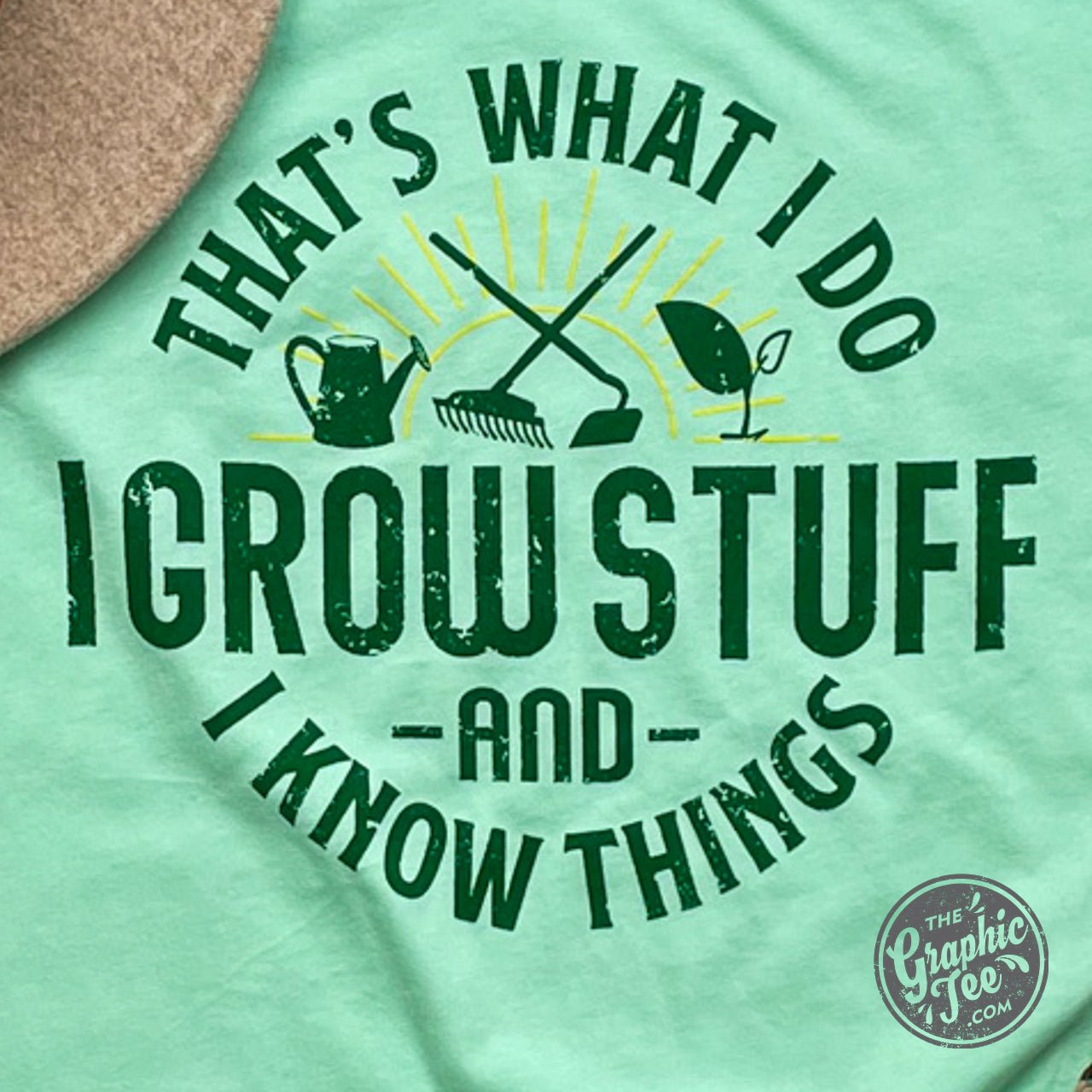 The Graphic Tee short sleeve graphic T-shirt with "That's What I Do I Grow Stuff" text, featuring a green plant illustration.