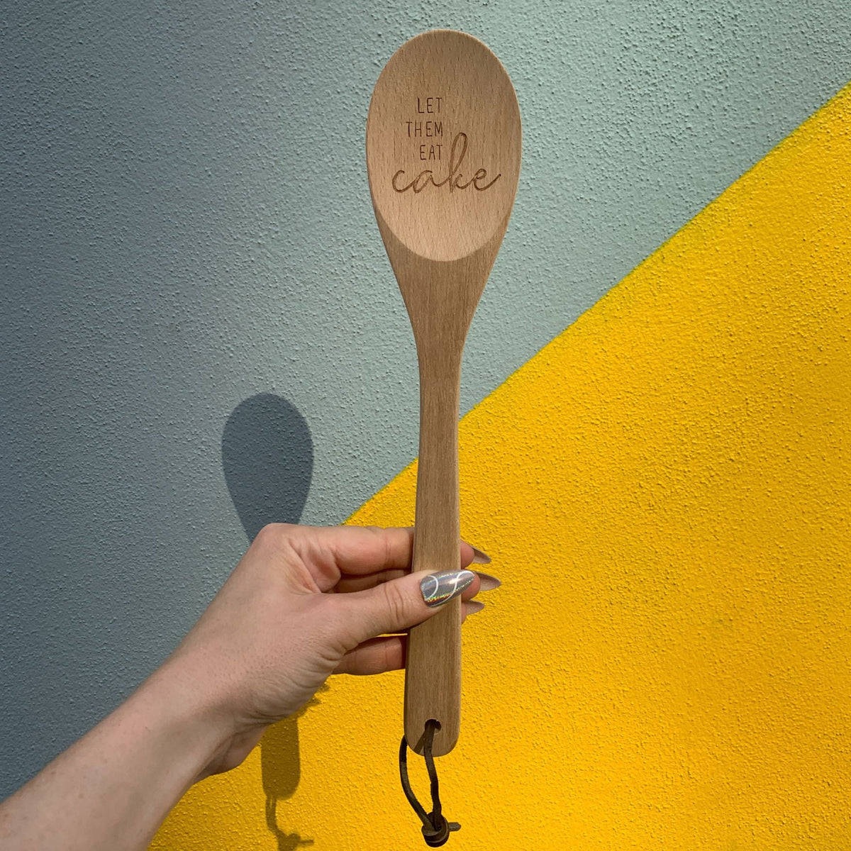 Marie Antoinette inspired wooden cooking spoon from The Bullish Store, displayed in muslin gift bag with playful sayings.