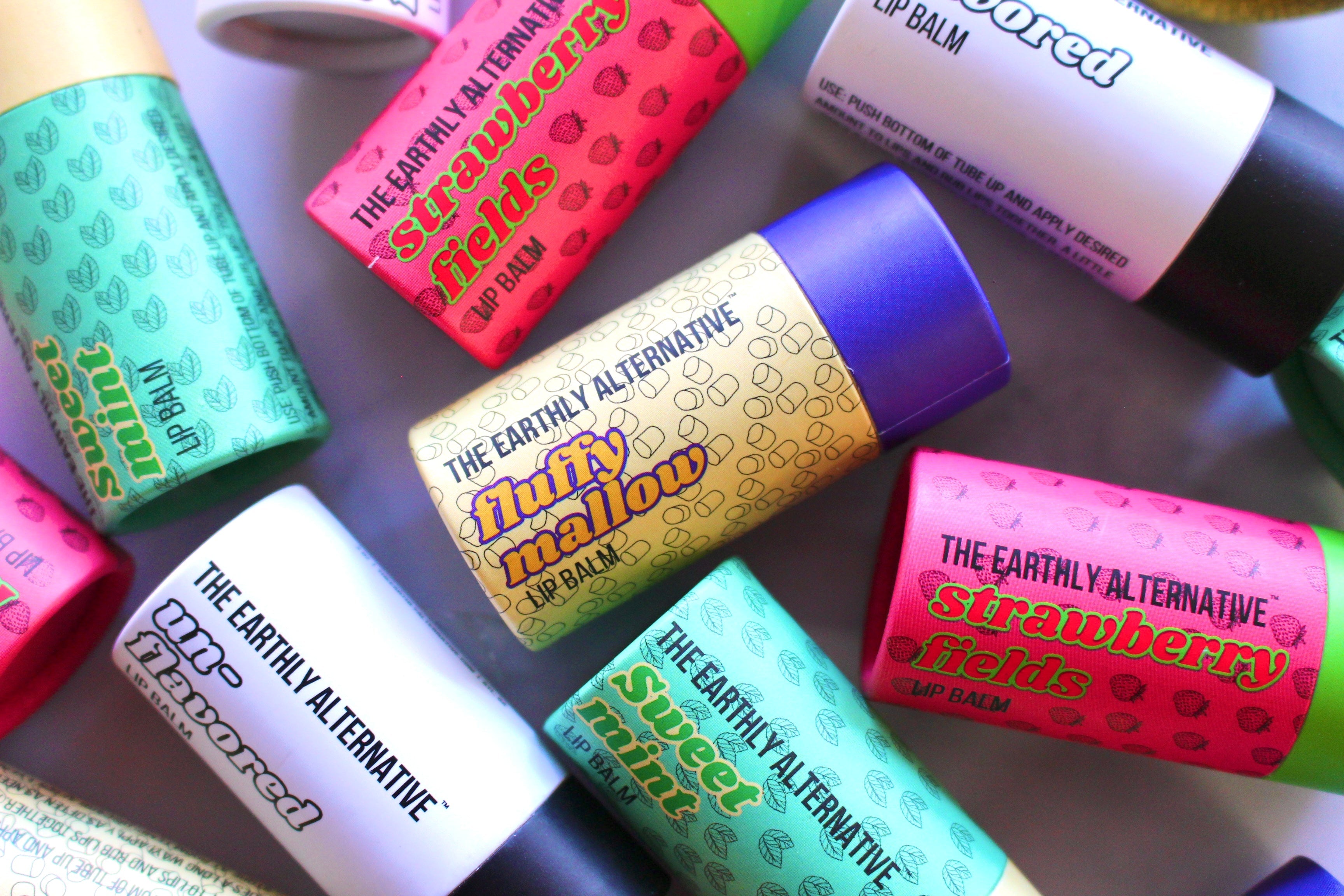 The Earthly Alternative fluffy mallow lip balm featuring a soft, creamy texture in a pastel-colored container.