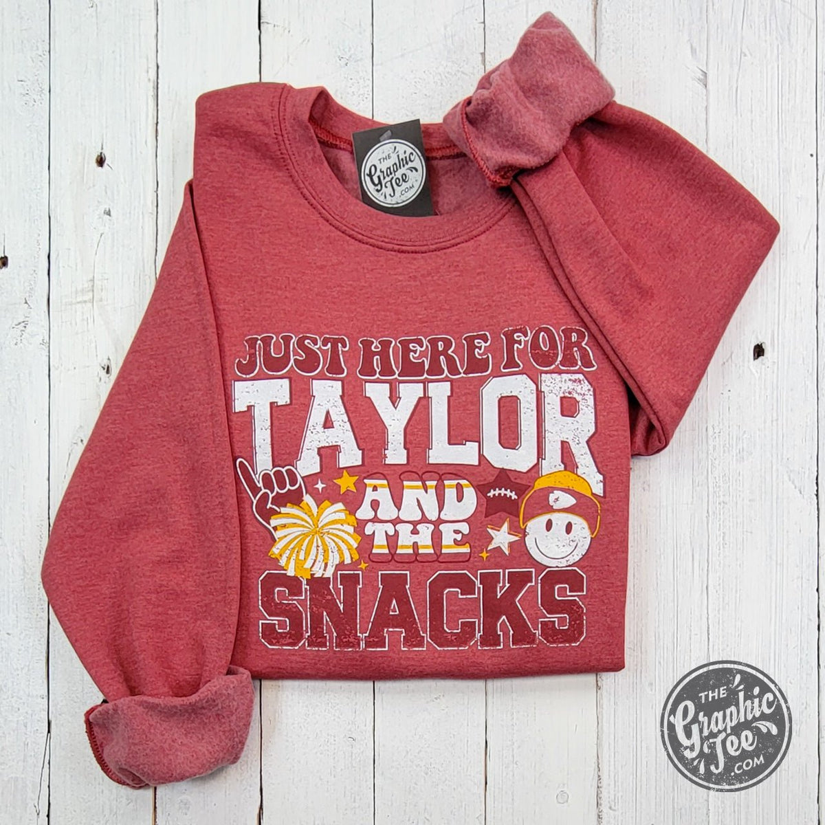 Heather sport scarlet crewneck sweatshirt from The Graphic Tee featuring "Just Here For Taylor And The Snacks" graphic design.