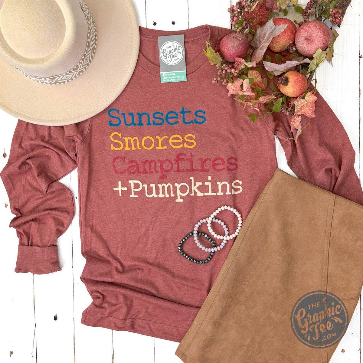 Long sleeve graphic tee by The Graphic Tee featuring sunset, s'mores, campfire, and pumpkin autumn scene design.