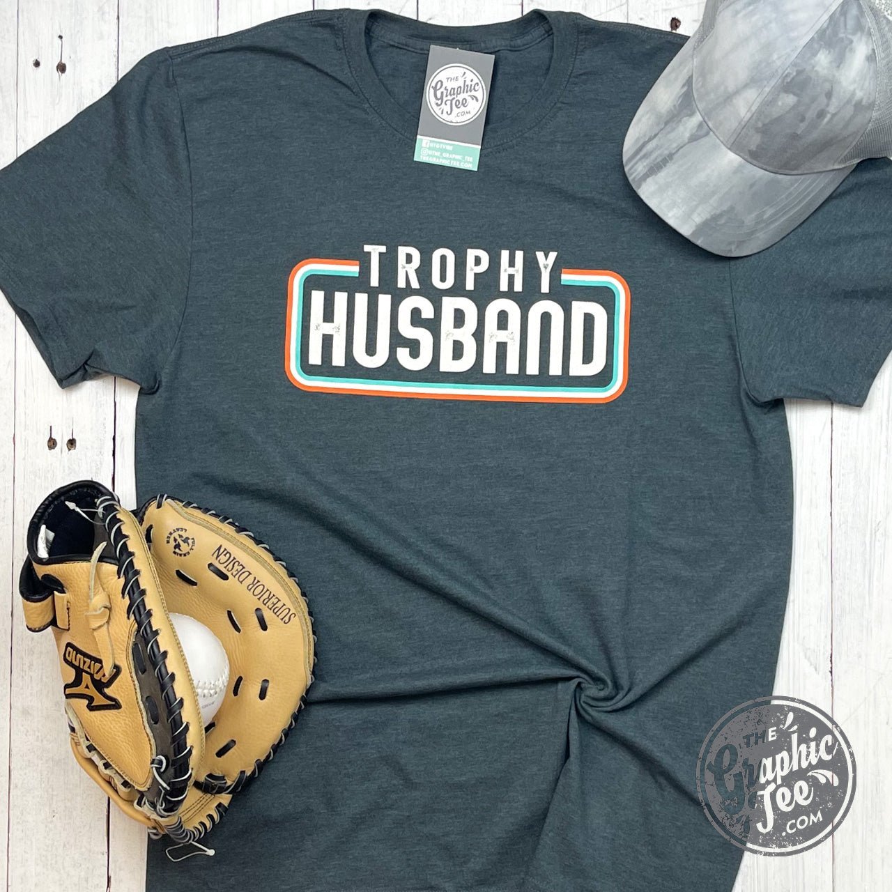 Unisex SS Graphic Tee by The Graphic Tee featuring a playful "Trophy Husband" design on soft cotton fabric.