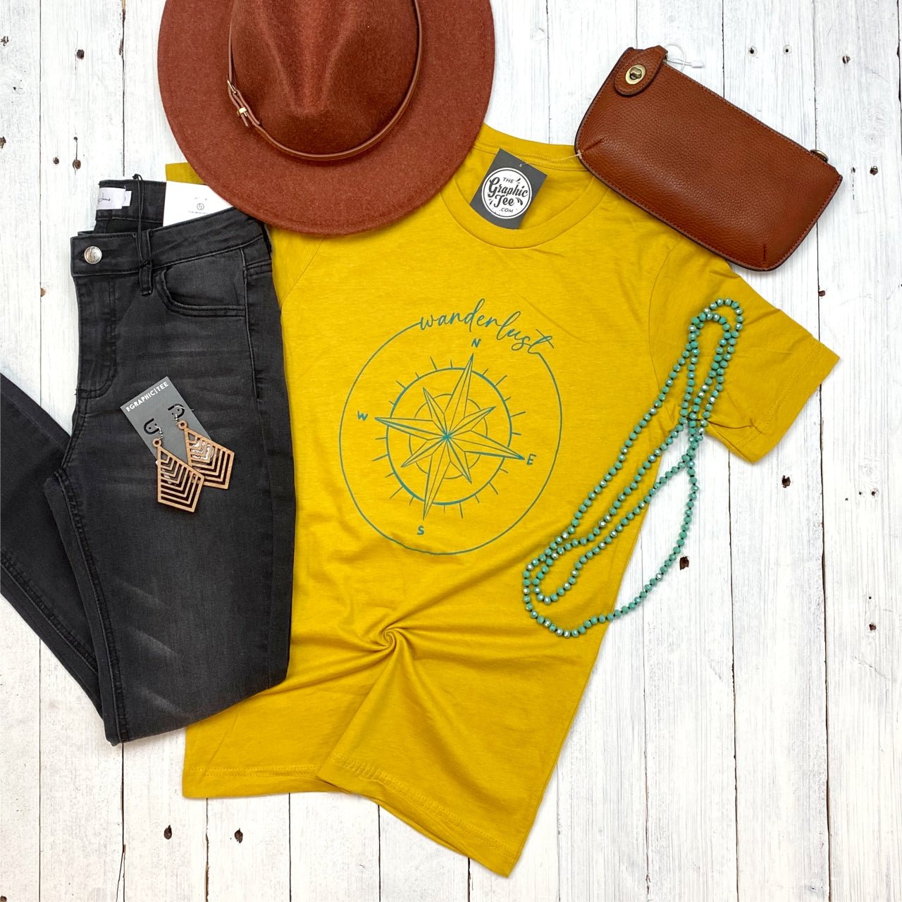 Light gray Wanderlust Tee from The Graphic Tee featuring a colorful travel-inspired graphic design on the front.