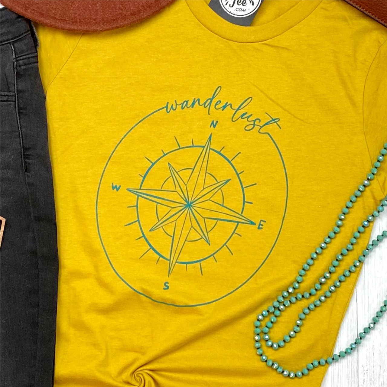 Short-sleeve graphic tee with wanderlust-themed design from The Graphic Tee, casual style perfect for travel and everyday wear.