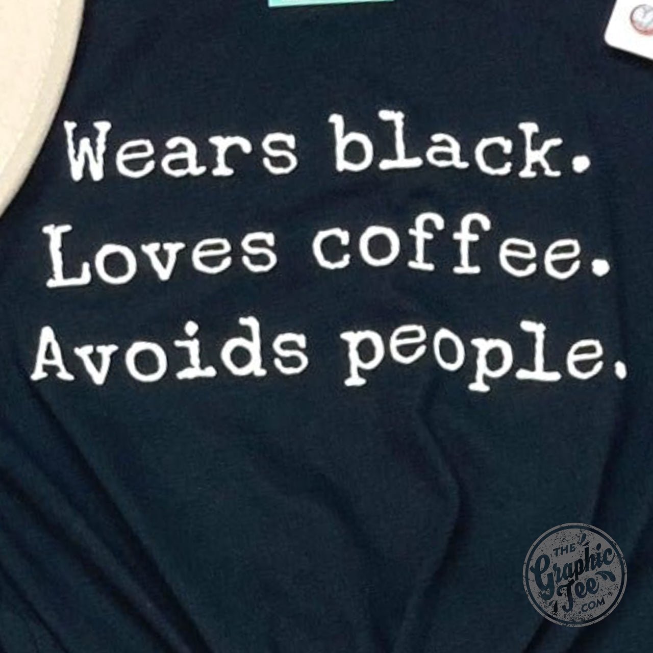 Black unisex short sleeve graphic tee featuring a design that says "Loves Coffee" and "Avoids People" by The Graphic Tee.