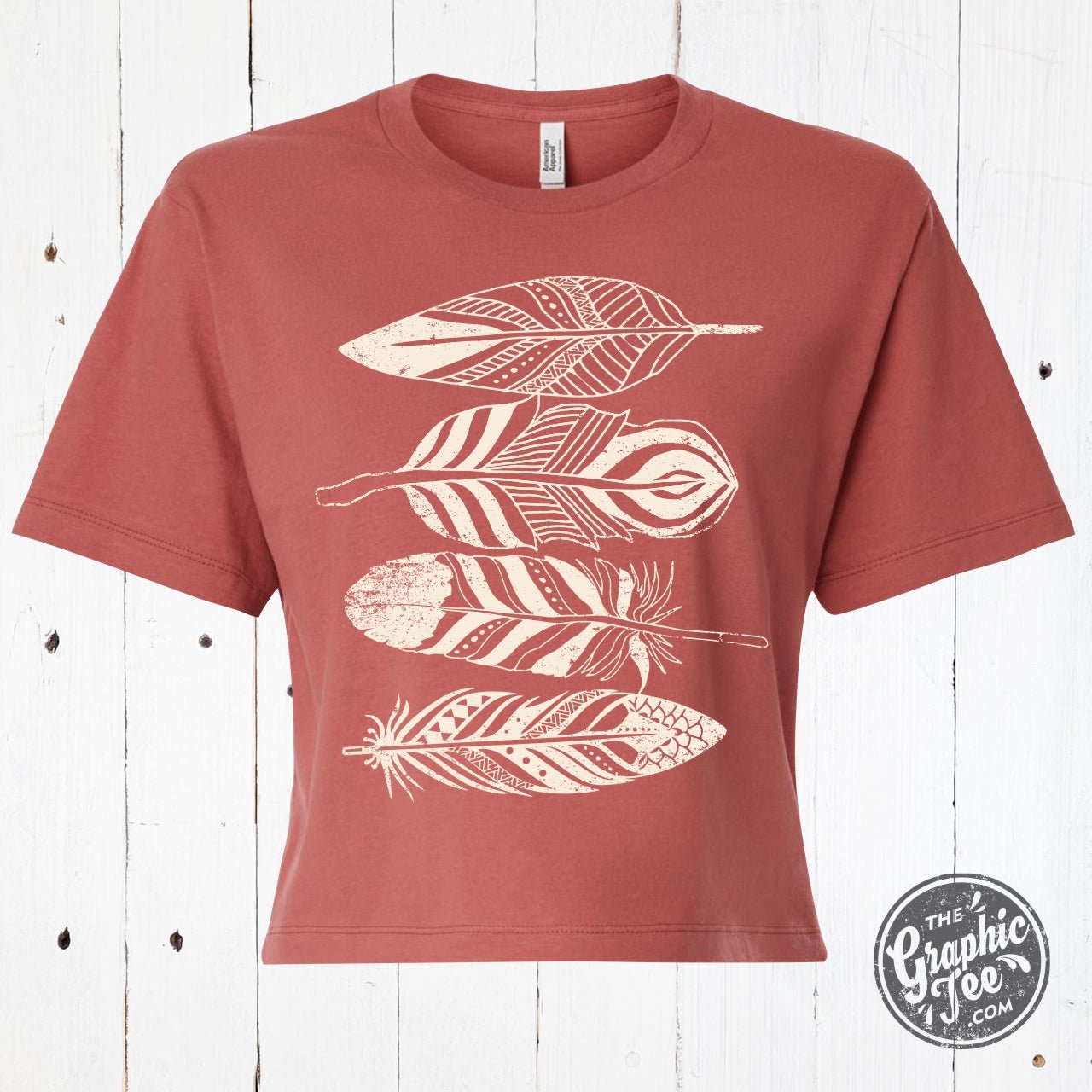 Wild Feathers waist-length crop tee by The Graphic Tee featuring a vibrant feather graphic on a casual SS graphic tee.