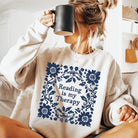 Black graphic tee from Anchored Grace Boutique featuring the phrase "Reading is My Therapy" in stylish white lettering.