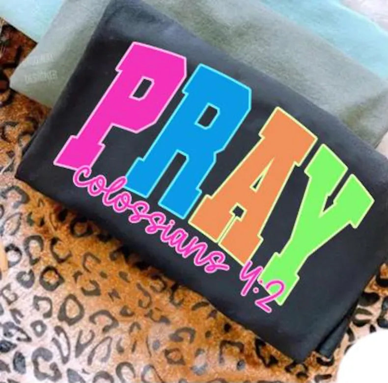 Pray Neon graphic tee by Anchored Grace Boutique featuring vibrant neon prayer design on casual cotton t-shirt.