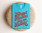 Black graphic tee from Anchored Grace Boutique featuring "Forget Flowers, Buy Me Books" design, casual and stylish for book lovers.