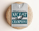 NFC East Champions Eagles graphic tee by Anchored Grace Boutique featuring team logo and bold design on a casual t-shirt