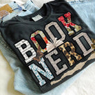 Black Book Nerd graphic tee by Anchored Grace Boutique featuring a stylish book-themed design on soft cotton fabric.
