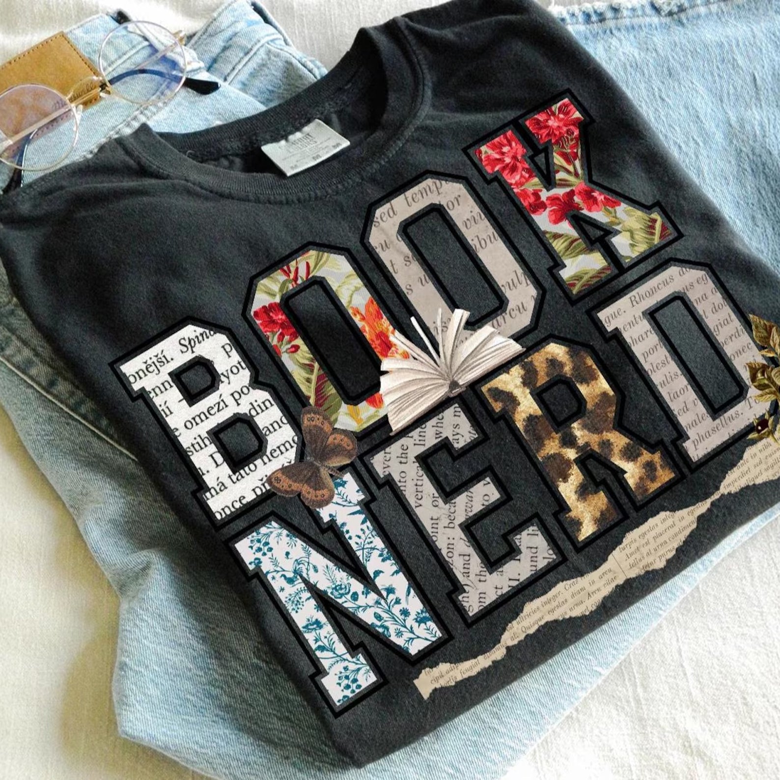 Black Book Nerd graphic tee by Anchored Grace Boutique featuring a stylish book-themed design on soft cotton fabric.