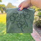 Green Shamrocks graphic tee by Anchored Grace Boutique featuring a playful shamrock design on soft cotton fabric.