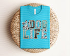 Dog Life graphic tee from Anchored Grace Boutique featuring a playful dog illustration on a casual cotton t-shirt.