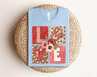 Love graphic tee by Anchored Grace Boutique featuring a stylish design on a casual cotton t-shirt.