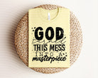 Black graphic tee featuring inspirational "God Turned This Mess Into a Masterpiece" design from Anchored Grace Boutique.