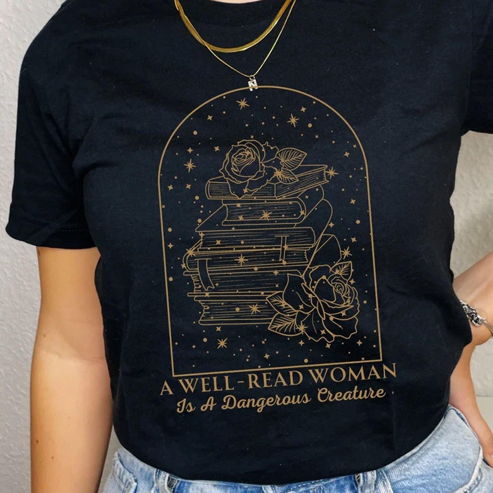 Well Read Woman is a Dangerous Creature graphic tee by Anchored Grace Boutique, featuring a stylish printed design on a black t-shirt.