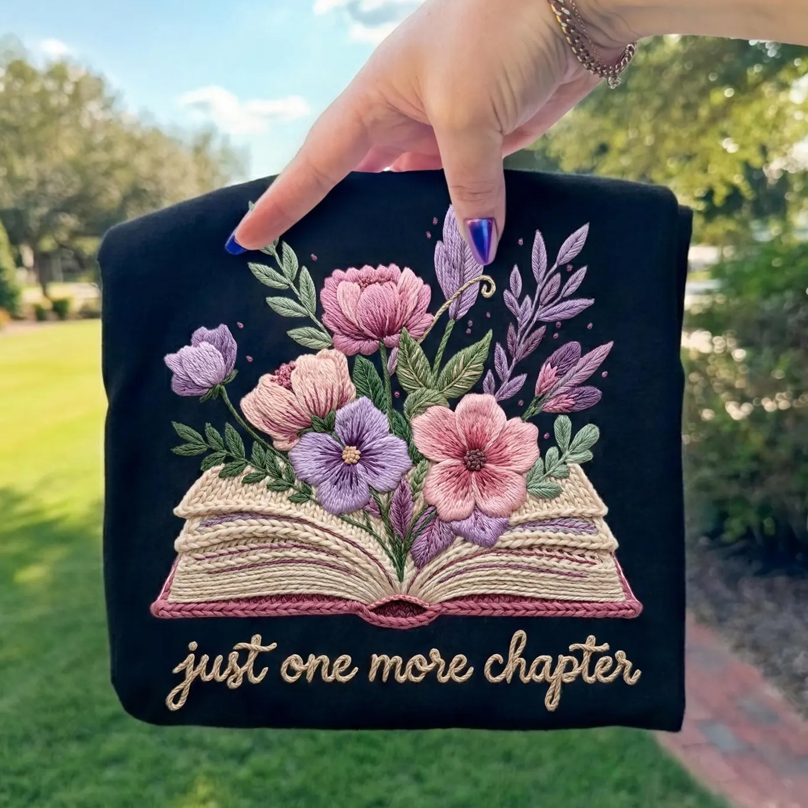 Black graphic tee from Anchored Grace Boutique featuring the phrase "Just One More Chapter" in white text.