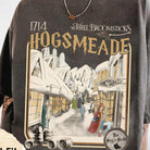 Hogsmeade graphic tee by Anchored Grace Boutique featuring a detailed illustration of Hogsmeade village on soft fabric.
