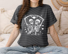 Black and white skeleton graphic tee by Anchored Grace Boutique, casual short-sleeve shirt with spooky skull design.