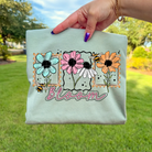 Colorful Bloom graphic tee by Anchored Grace Boutique featuring floral design and casual fit.