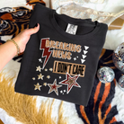 Black graphic tee from Anchored Grace Boutique featuring bold "Breaking News I Don't Care" text in white print.