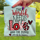 Bright white graphic tee featuring "The World Needs Love" slogan in colorful lettering, from Anchored Grace Boutique.