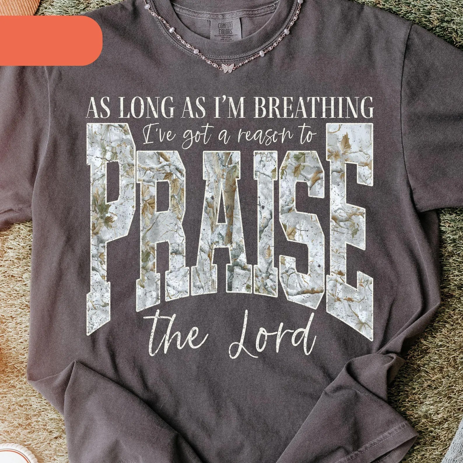 Black graphic tee from Anchored Grace Boutique featuring the phrase "I've Got a Reason to Praise the Lord" in stylish font.