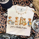 Black graphic tee featuring a playful "Just a Thrifty Heifer" design from Anchored Grace Boutique, casual and stylish for everyday wear.