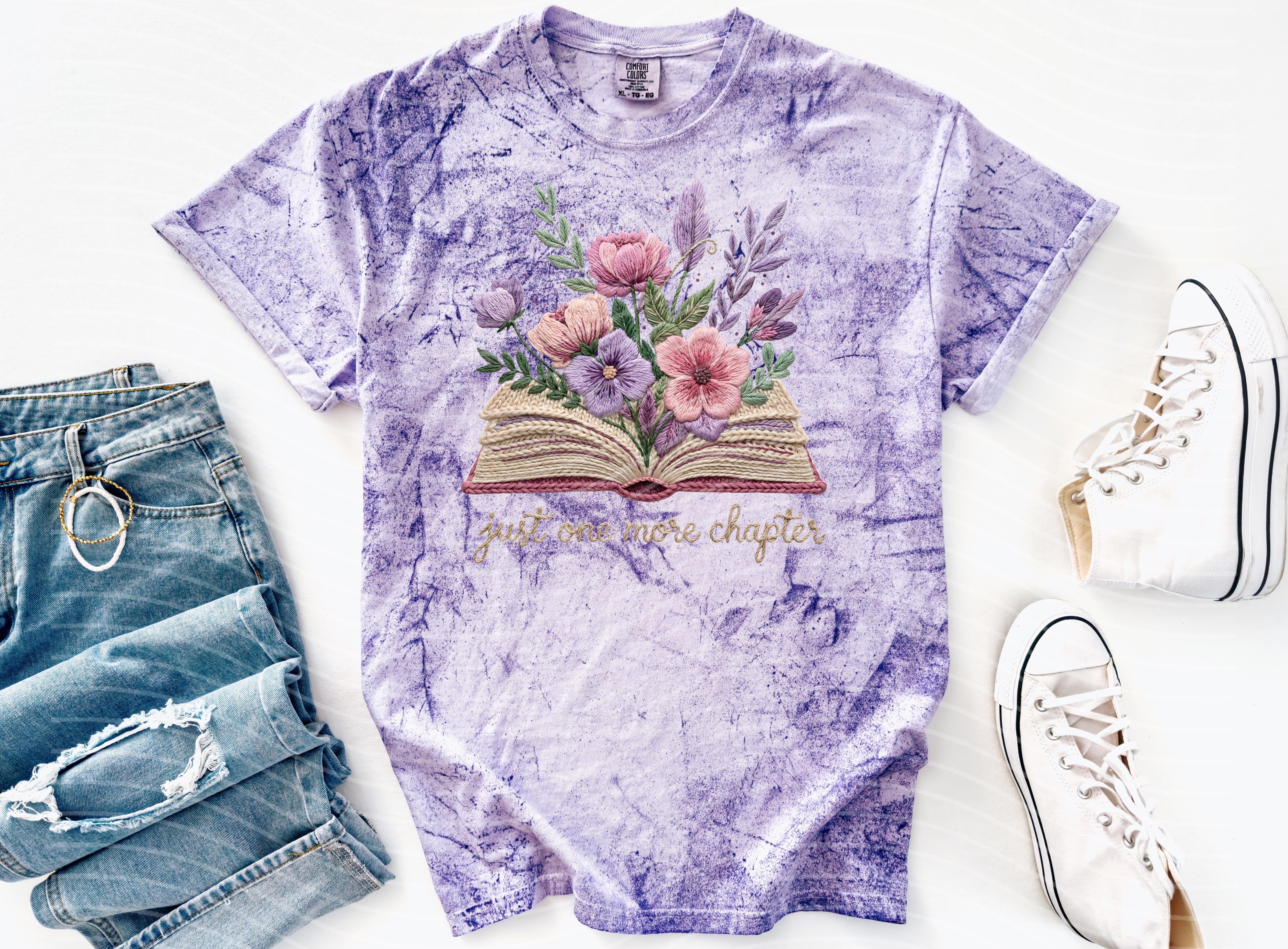 Black graphic tee from Anchored Grace Boutique featuring "Just One More Chapter" text and book-themed design.
