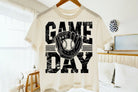 Black Game Day graphic tee by Anchored Grace Boutique featuring bold team logo and sporty design on soft cotton fabric.