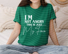 Black graphic tee from Anchored Grace Boutique with "I'm Not Angry This is Just My Face" printed design, casual and comfortable fit.