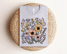Spring floral graphic tee by Anchored Grace Boutique featuring colorful floral design on a comfortable cotton t-shirt.