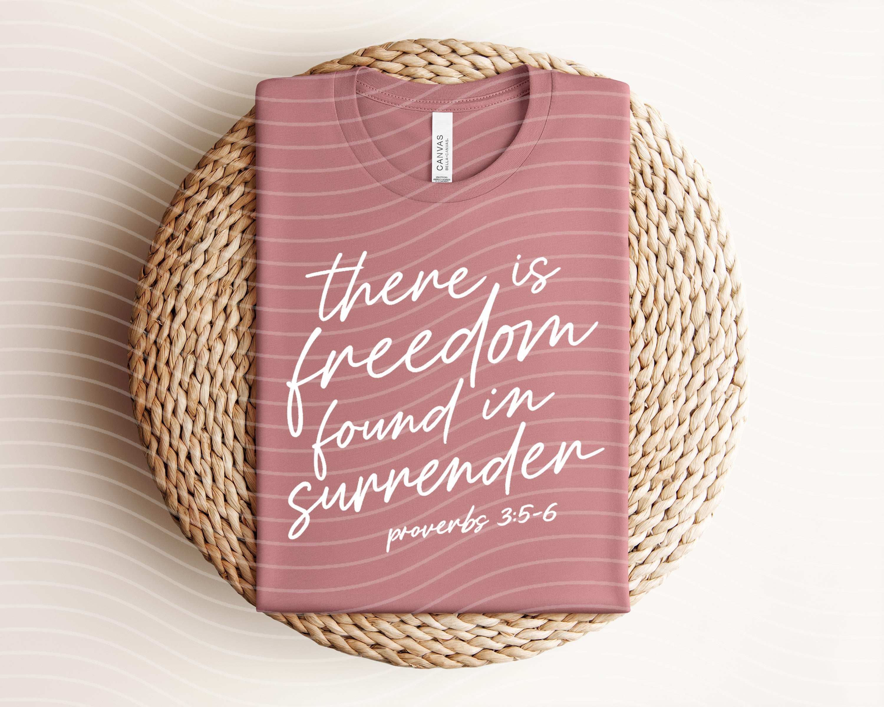 Black graphic tee from Anchored Grace Boutique featuring the quote "There is Freedom Found in Surrender" in stylish white lettering.