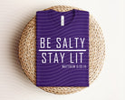 Black Be Salty Stay Lit graphic tee by Anchored Grace Boutique featuring bold white text and casual fit.
