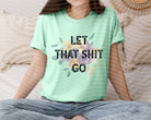 Gray graphic tee by Anchored Grace Boutique featuring bold "Let That Sh** Go" print on the front. Casual, comfortable t-shirt.