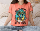 Life is Better at the Beach graphic tee by Anchored Grace Boutique, featuring a coastal-themed design on a casual cotton t-shirt.