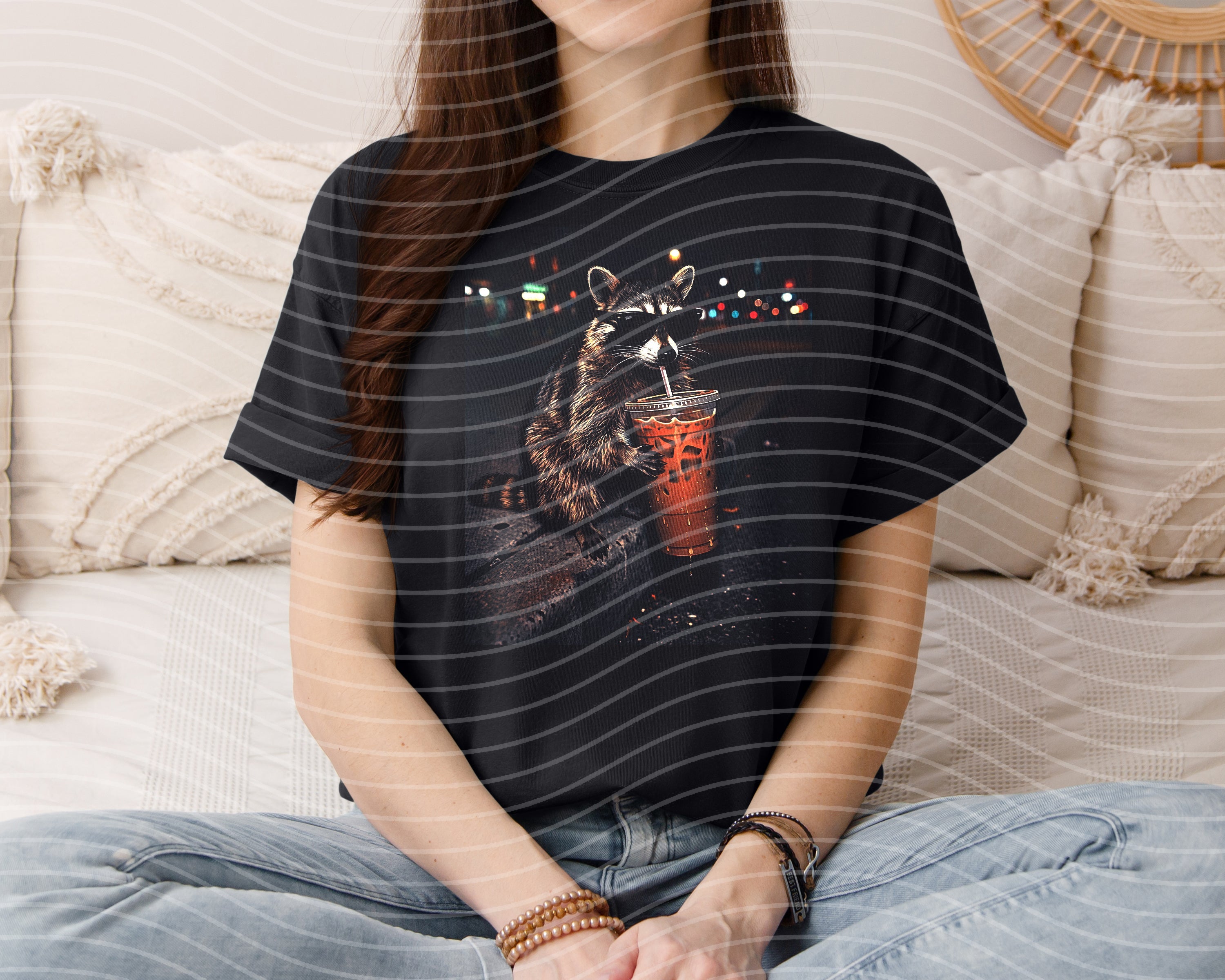 Iced coffee raccoon graphic tee from Anchored Grace Boutique showing a playful raccoon holding a coffee cup on soft cotton fabric.