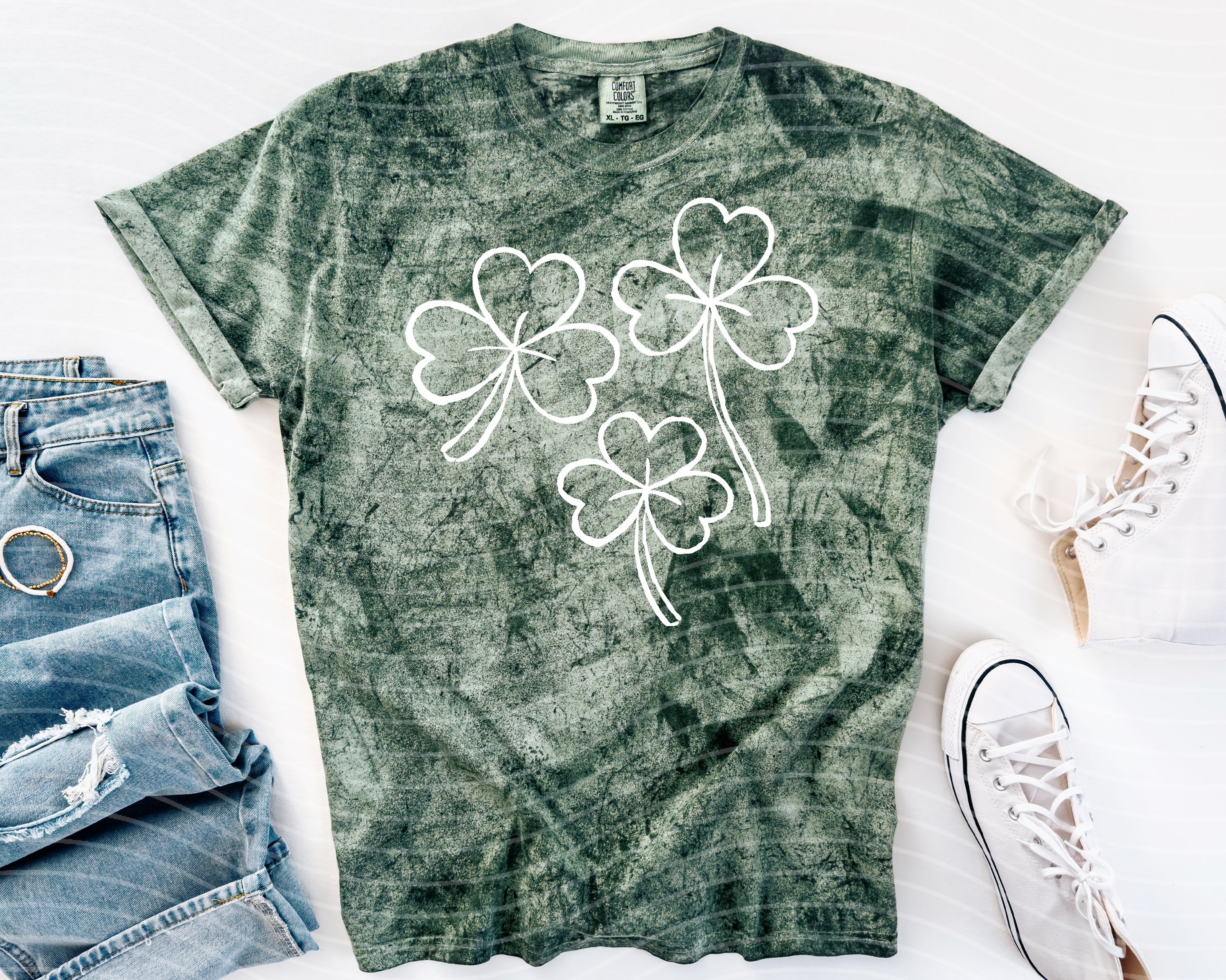 Black Shamrocks graphic tee by Anchored Grace Boutique featuring a vibrant shamrock design on soft cotton fabric.