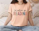 Black graphic tee from Anchored Grace Boutique with "I'd Rather Be Reading" print, casual style, soft fabric, and comfortable fit.