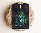 Aurora Dark Graphic Tee by Anchored Grace Boutique featuring a stylish, dark-colored graphic design on a casual tee shirt.