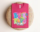 Black Book Nerd graphic tee from Anchored Grace Boutique featuring a book-themed design on soft cotton fabric.